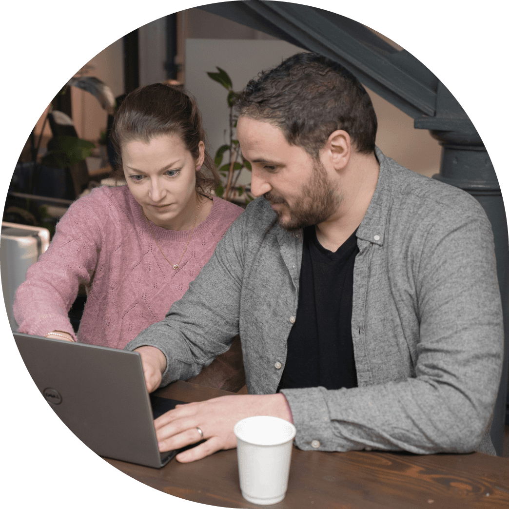 Two Fire team members looking at a laptop and discussing a project.